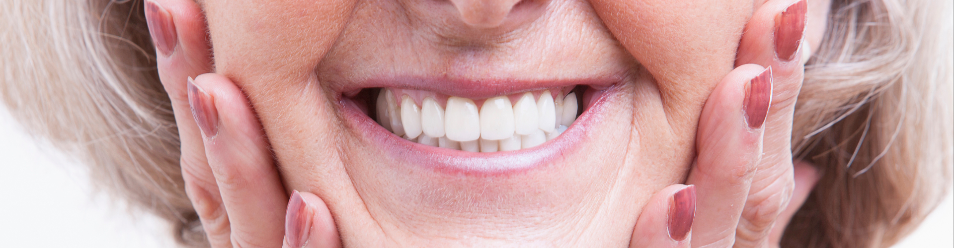 Smiling woman holding her cheeks.
